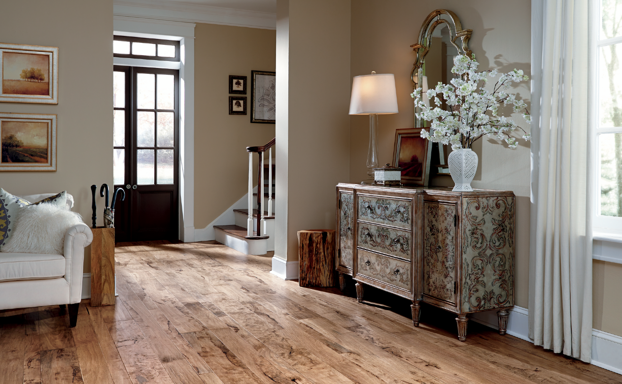 warm toned hardwood flooring in living room with white couch and natural decor.